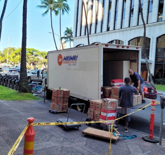 Package couriers in Honolulu load packages into the delivery truck.