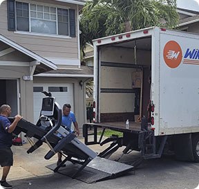 Hawaii moving company employees load gym and work out equipment into a truck.